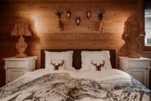 Schlafzimmer mit einem Bett mit Geweihen an der Wand in der Unterkunft Bergwelt Grindelwald Residence in Grindelwald