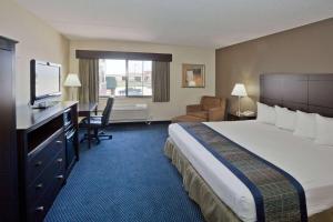 AmericInn by Wyndham Lincoln South في لينكولن: غرفه فندقيه سرير كبير وتلفزيون