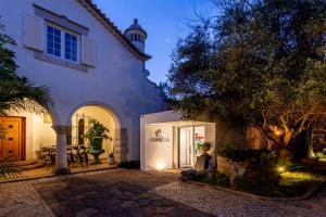 une maison blanche avec une cour en face dans l'établissement Casa Vela Boutique House, à Cascais