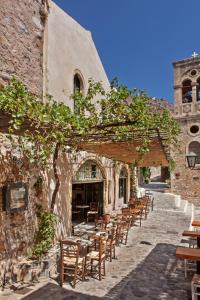 une rangée de tables et de chaises à l'extérieur d'un bâtiment dans l'établissement Byzantino Boutique Hotel, à Monemvasia