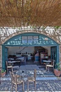 d'une terrasse avec des tables et des chaises et un plafond en bois. dans l'établissement Byzantino Boutique Hotel, à Monemvasia