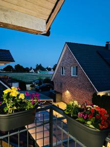 a balcony with two large pots of flowers on it at Charmantes Familiennest nähe Hamburg Arena & Airport in Halstenbek