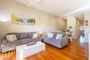 a living room with two couches and a table at Starfish Lodge, 2-1a Messines St - pet friendly, air con and Wi-Fi in Shoal Bay