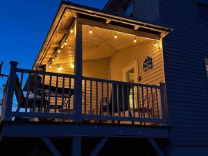 een afgeschermde veranda met stoelen en verlichting op een huis bij The Tides in Hampton