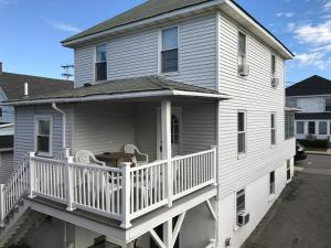 een huis met een balkon met een tafel en stoelen bij The Tides in Hampton