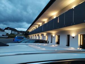 Une rangée de voitures garées sur un parking dans l'établissement HBR HÔTEL By HÔTEL, à Balma