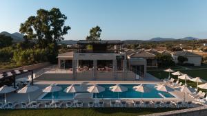 - une vue aérienne sur un complexe avec une piscine et des parasols dans l'établissement Niriides Luxury Villas, à Methoni