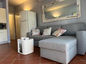 ein Wohnzimmer mit einem Sofa und einem Kühlschrank in der Unterkunft Porto Coda Cavallo Salina Bamba in Capo Coda Cavallo