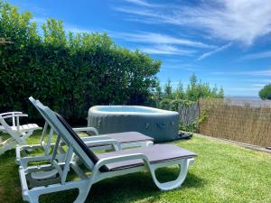 2 chaises longues et un bain à remous dans la cour dans l'établissement Vistas do Minho, à Caminha