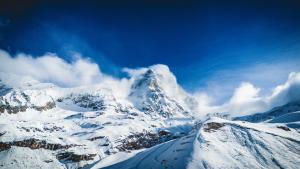 een berg bedekt met sneeuw met een blauwe lucht bij La Cresta Chalet in Breuil-Cervinia