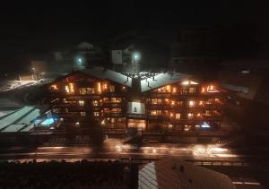 een groot gebouw 's nachts met verlichting bij La Cresta Chalet in Breuil-Cervinia