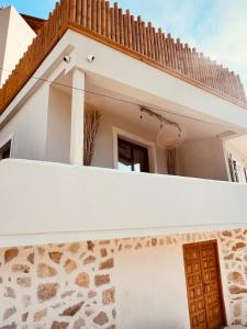 a house with a white wall and a door at Casa Boha in Dhërmi