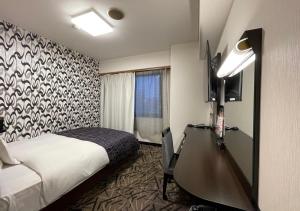 a hotel room with a bed and a desk at APA Hotel Kitakami Ekinishi in Kitakami