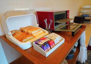 a counter top with a box of bread and a microwave at APA Hotel Kitakami Ekinishi in Kitakami