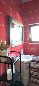 baño rojo con lavabo y ventana en Domki Letniskowe oraz Chata Grillowa " Nad Zalewem "Bliżyn, en Bliżyn