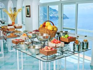 - un buffet avec des paniers de fruits sur une table en verre dans l'établissement Hotel Le Agavi, à Positano