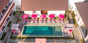 an overhead view of a pool with pink umbrellas and chairs at PinkPrivate Balangan - for Cool Adults Only in Jimbaran