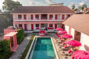 a house with pink umbrellas and a swimming pool at PinkPrivate Balangan - for Cool Adults Only in Jimbaran