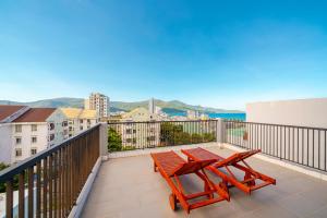 NM Apartment Beach Da Nang في دا نانغ: بلكونه عليها طاوله ومقعد