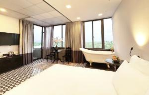 - une chambre d'hôtel avec un lit et une baignoire dans l'établissement TTR Skypool View Hotel, à Đà Lạt