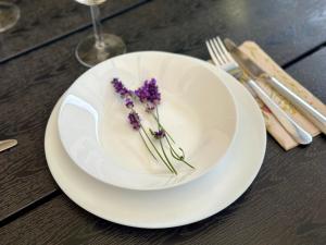 a white plate with purple flowers on a table at Apartamenty A&M in Stargard