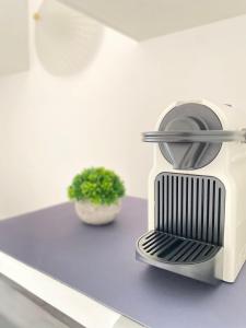 a toaster sitting on a counter next to a plant at Le Péruvien - Saint-Cyr-L'Ecole - Free Parking in Saint-Cyr-lʼÉcole