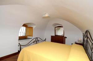 een slaapkamer met een geel bed en een raam bij Casa Rossa in Ravello