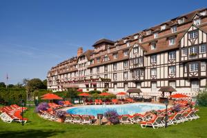 un grande edificio con piscina di fronte di Hôtel Barrière L'Hôtel du Golf a Deauville