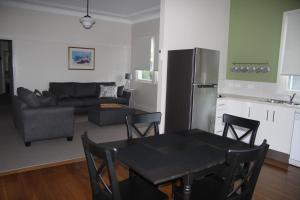 cocina y sala de estar con mesa y nevera en Victoria Street Apartments, en Grafton