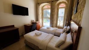 A bed or beds in a room at Azzahra Boutique Hotel & Restaurant - Jerusalem