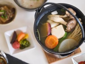 un tazón de sopa con verduras y otros alimentos en HOTEL HOLISTIC RESORT - Vacation STAY 34557v, en Taiji