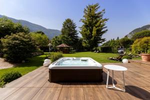 een hot tub bovenop een houten terras bij Hotel Lido - green & slow life in Molveno