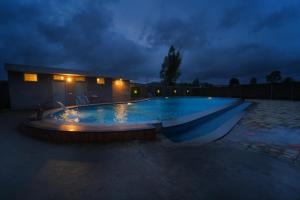 una grande piscina di notte con un cielo nuvoloso di SIGNATURE INN a Chikmagalūr