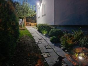 un giardino di notte con un sentiero in pietra di Apartmán na Vyhlídce a Šumperk