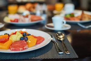 um prato de fruta numa mesa com utensílios em Hilton Belgrade em Belgrado