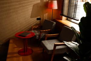 una habitación con 2 sillas y una mesa con un libro. en Rotel Boutique Hotel, en Kutaisi