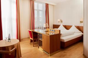 una camera d'albergo con letto e tavolo di Hotel Zum Schiff a Friburgo in Brisgovia