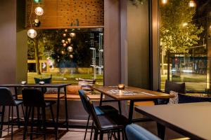 un restaurant avec des tables et des chaises et une fenêtre dans l'établissement Motel One Wiesbaden, à Wiesbaden