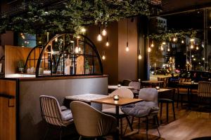 un restaurant avec des tables et des chaises ainsi qu'un bar dans l'établissement Motel One Wiesbaden, à Wiesbaden