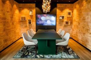 une salle de conférence avec une table verte et des chaises blanches dans l'établissement Motel One Wiesbaden, à Wiesbaden