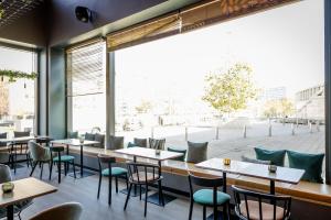 un restaurant avec des tables et des chaises et une grande fenêtre dans l'établissement Motel One Wiesbaden, à Wiesbaden