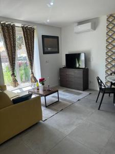 a living room with a couch and a tv at Mozart Cosy Love room in Chasse-sur-Rhône