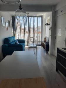 sala de estar con sofá azul y mesa en Ático centro Huelva con parking, en Huelva