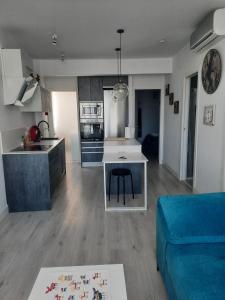 cocina y sala de estar con sofá y mesa en Ático centro Huelva con parking, en Huelva