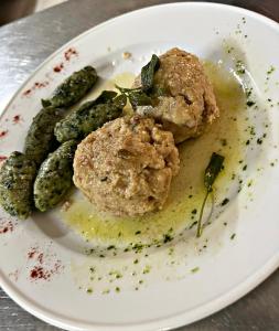 einen Teller mit Fleischbällchen und Gemüse auf dem Tisch in der Unterkunft Hotel Selva in Folgarida