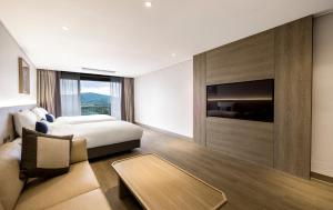 a hotel room with a bed and a tv at Kensington Resort Gyeongju in Gyeongju