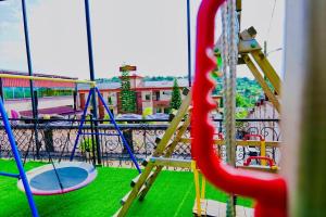 vistas a un parque infantil con tobogán y columpios en Dajoll Hotel, en Yaoundé