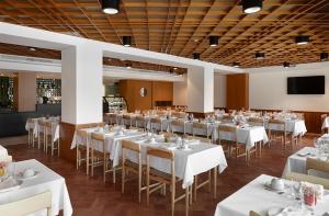 - une salle de banquet avec des tables et des chaises blanches dans l'établissement Abrigo da Montanha Hotel Rural, à Sabugueiro