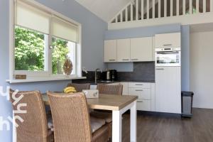 een keuken met een houten tafel en stoelen bij OV072 Exklusives 4P-Ferienhaus in bester Lage in Giethoorn in Giethoorn