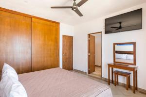 um quarto com uma cama e uma ventoinha de tecto em Villas Najo' Isla Mujeres. em Ilha das Mulheres